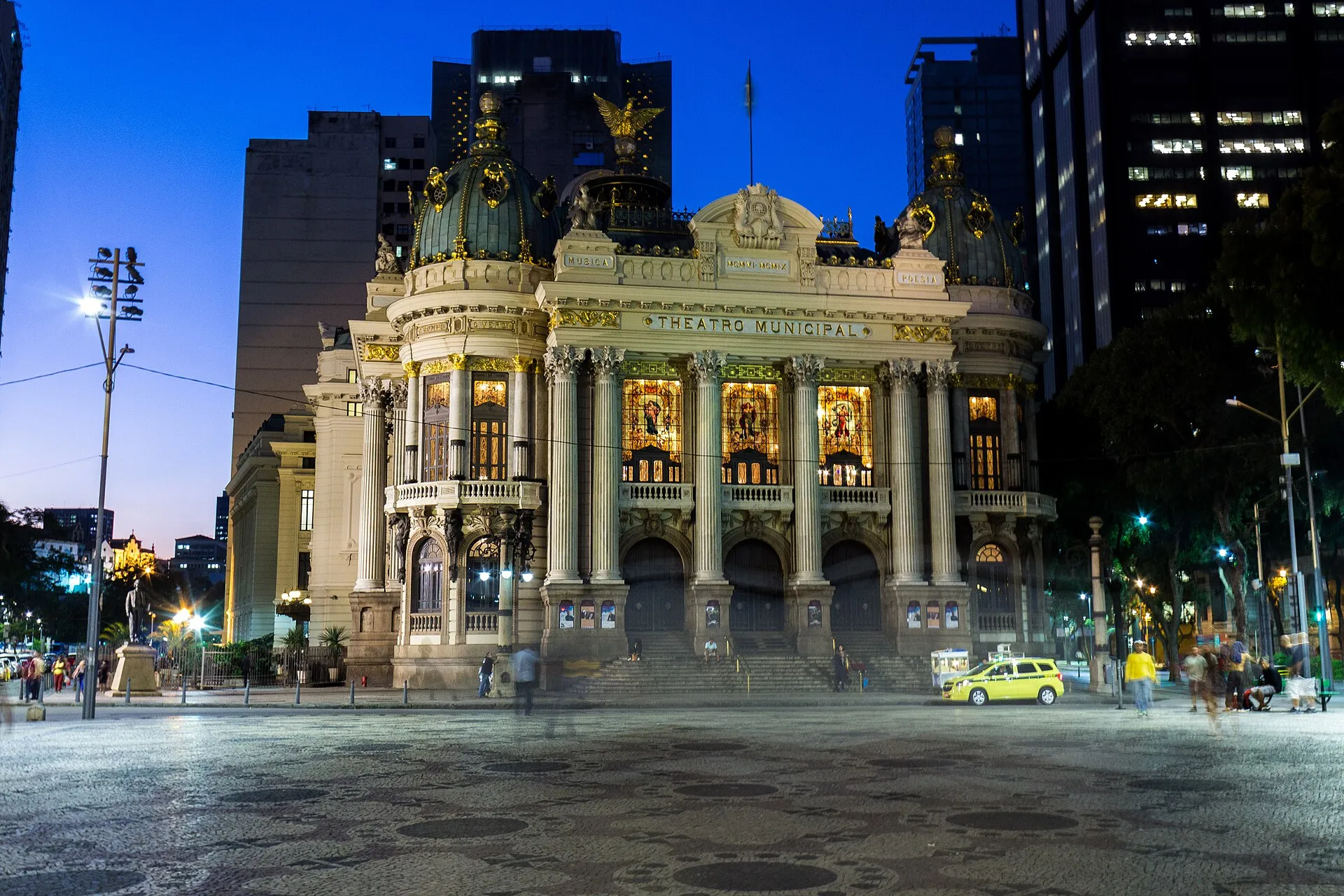 Fachada do Theatro Municipal do Rio de Janeiro ao entardecer, com as inscrições Música e Poesia acima da entrada.
